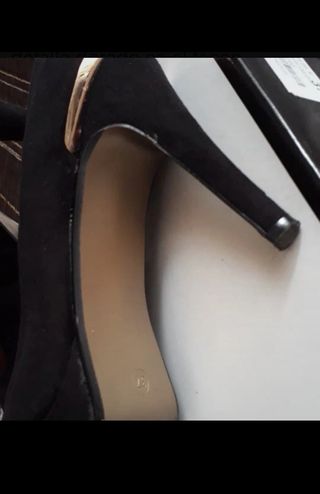 Zapatos de antelina en negro de tacón alto.