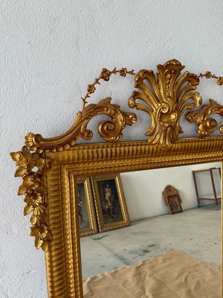 Elegante espejo isabelino dorado en oro fino.