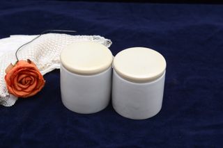 Dos tarros vintage de farmacia de loza blanca tapa