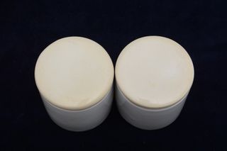 Dos tarros vintage de farmacia de loza blanca tapa