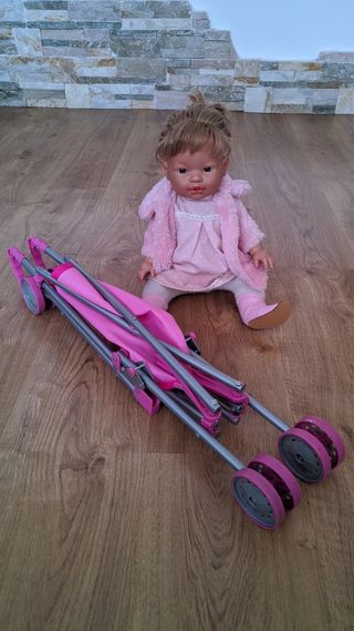 Bebé niña con carro de paseo.