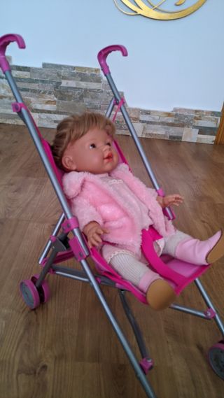 Bebé niña con carro de paseo.