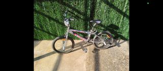 Bicicleta freestyle plateada tipo BMX 
