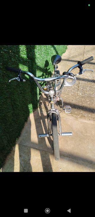 Bicicleta freestyle plateada tipo BMX 