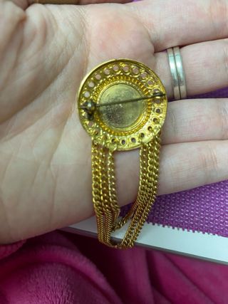 Broche dorado con diamante rojo