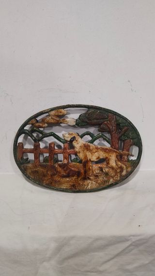 Antiguo salvamanteles reposa ollas hierro perro