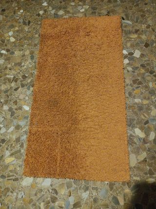 Alfombra naranja pie de cama
