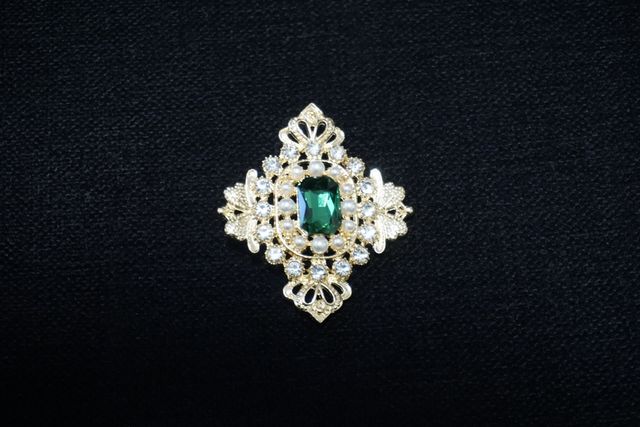 Broche de pedrería con esmeralda
