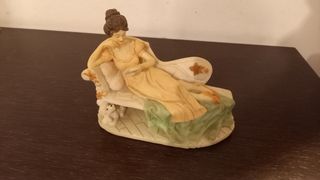 Figura decoracion. Mujer leyendo en diván