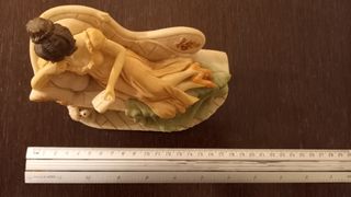 Figura decoracion. Mujer leyendo en diván