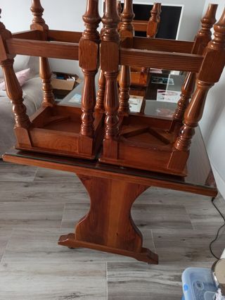 Mesa de cocina con su cristal y cuatro bancos.