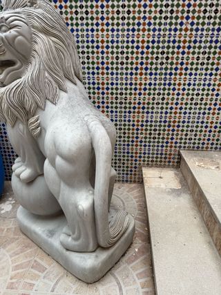 Pareja de esculturas de leones tallados en mármol.