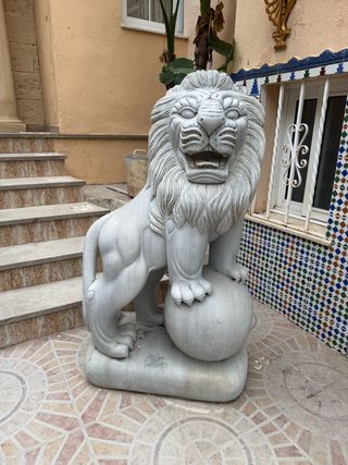 Pareja de esculturas de leones tallados en mármol.