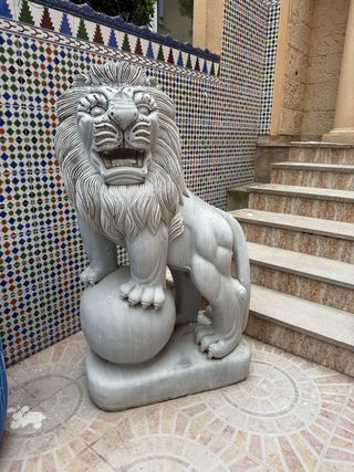 Pareja de esculturas de leones tallados en mármol.