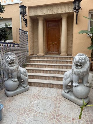 Pareja de esculturas de leones tallados en mármol.