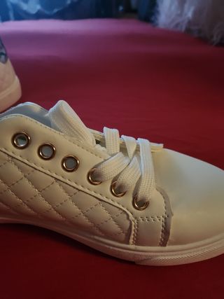 Zapatos blancas y doradas