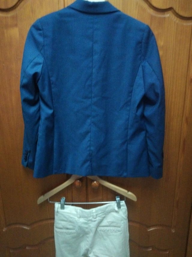Chaqueta azul y pantalón beige.