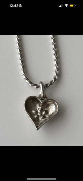 Collar pendiente en forma de corazón plateado.