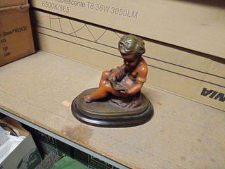 Figura niño leyendo escultura sobre base de madera
