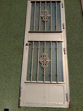 Puerta de acero, con cristal y reja.
