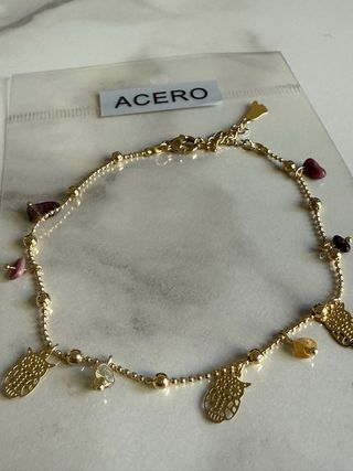 Tobillera de acero dorado con buhos y piedras