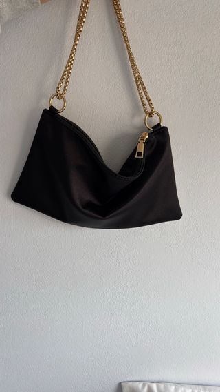 Bolso de mano negro con cadena dorada