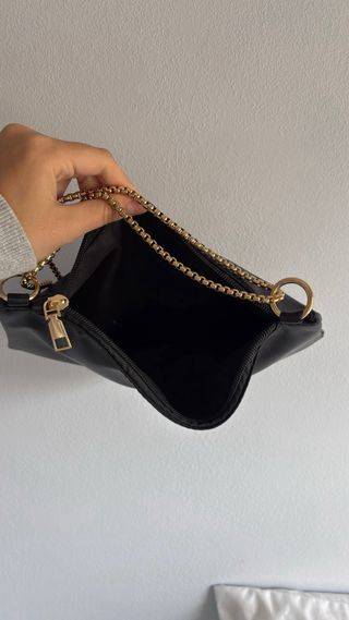 Bolso de mano negro con cadena dorada