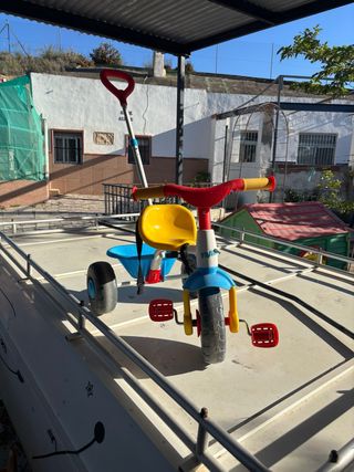 Triciclo infantil rojo, amarillo y azul