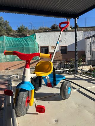 Triciclo infantil rojo, amarillo y azul