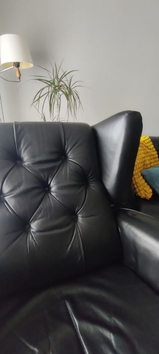 Sofá de piel negra con botones en el respaldo