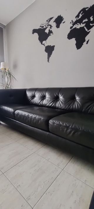 Sofá de piel negra con botones en el respaldo