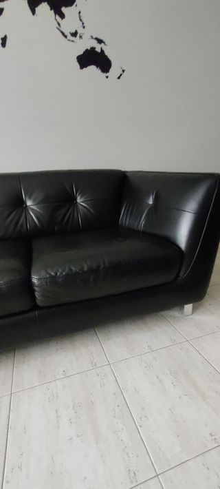 Sofá de piel negra con botones en el respaldo