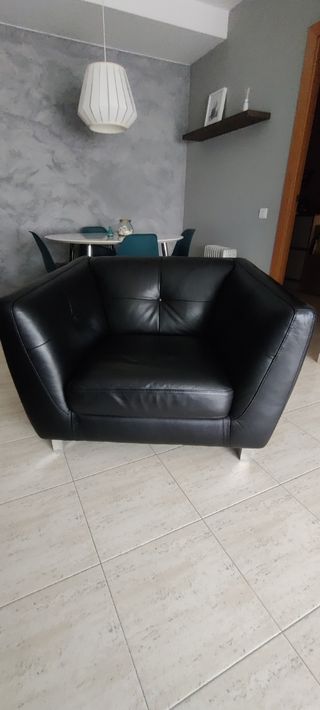 Sofá de piel negra con botones en el respaldo