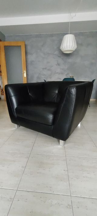 Sofá de piel negra con botones en el respaldo