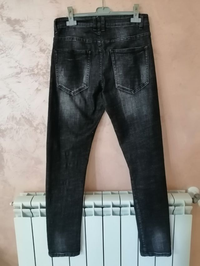 Jeans uomo colore scuro effetto strappato.