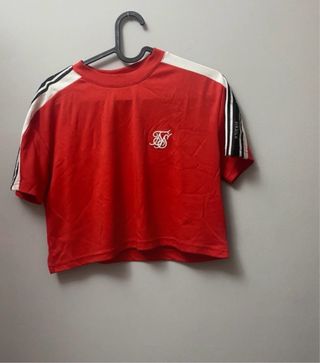 Conjunto Siksilk: Leggings negros y top rojo.