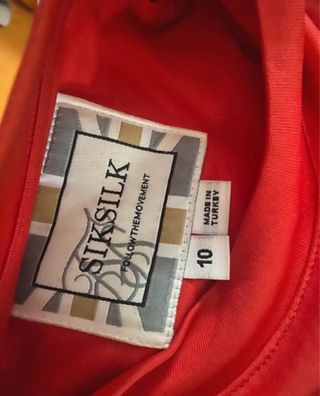 Conjunto Siksilk: Leggings negros y top rojo.