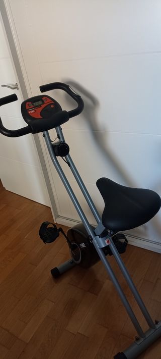 Bicicleta estática plegable con sillín acolchado