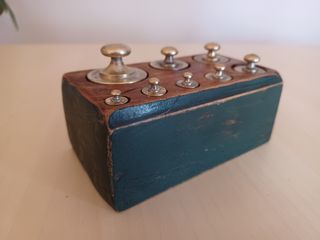 Pesas francesas antiguas en soporte madera verde