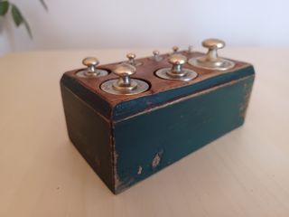 Pesas francesas antiguas en soporte madera verde