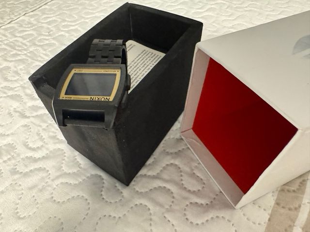 Reloj Nixon unisex negro y dorado