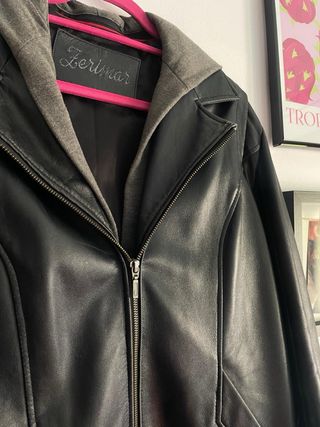 Chaqueta de cuero negra con capucha gris.