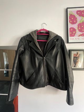 Chaqueta de cuero negra con capucha gris.
