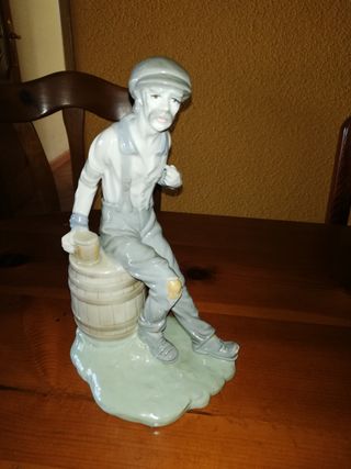 Figura de porcelana señor sentado.
