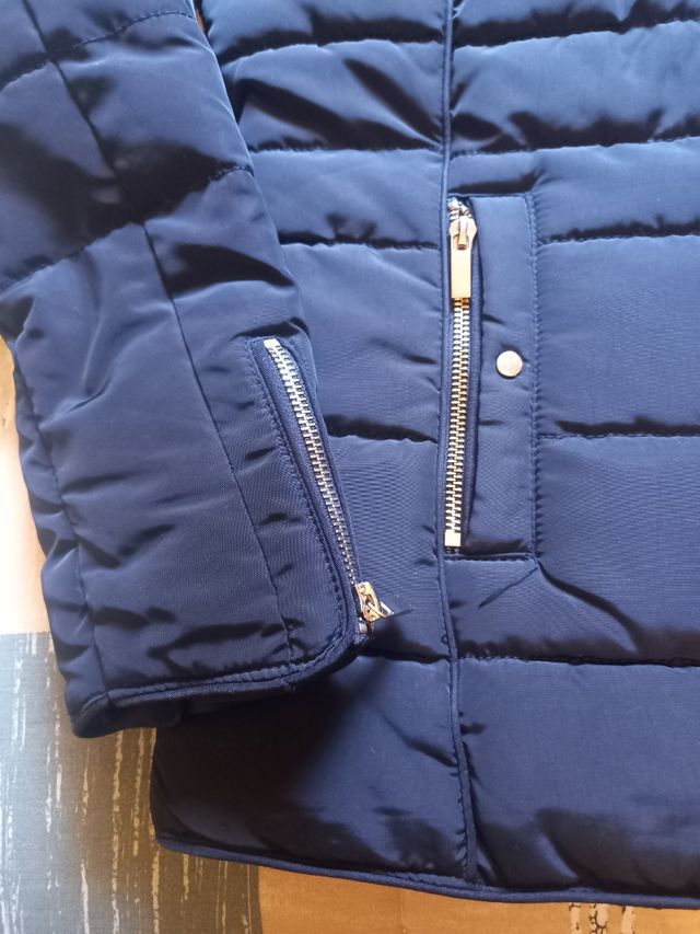 Plumas.Chaqueta acolchada negra con cuello de pelo