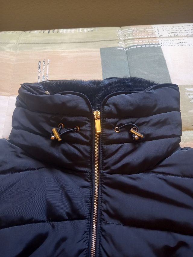 Plumas.Chaqueta acolchada negra con cuello de pelo