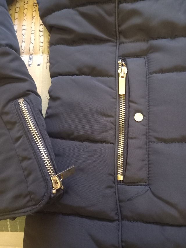 Plumas.Chaqueta acolchada negra con cuello de pelo