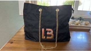 Bolso negro acolchado con cadena dorada