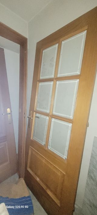 Puerta de madera con cristal con sus marcos.
