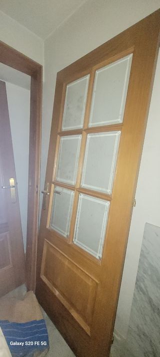 Puerta de madera con cristal con sus marcos.